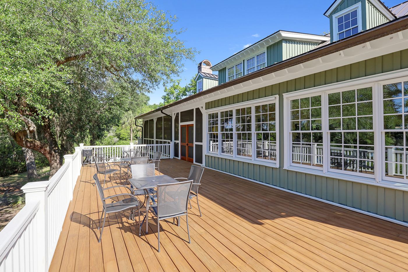 Outdoor clubhouse terrace beneath mature trees
